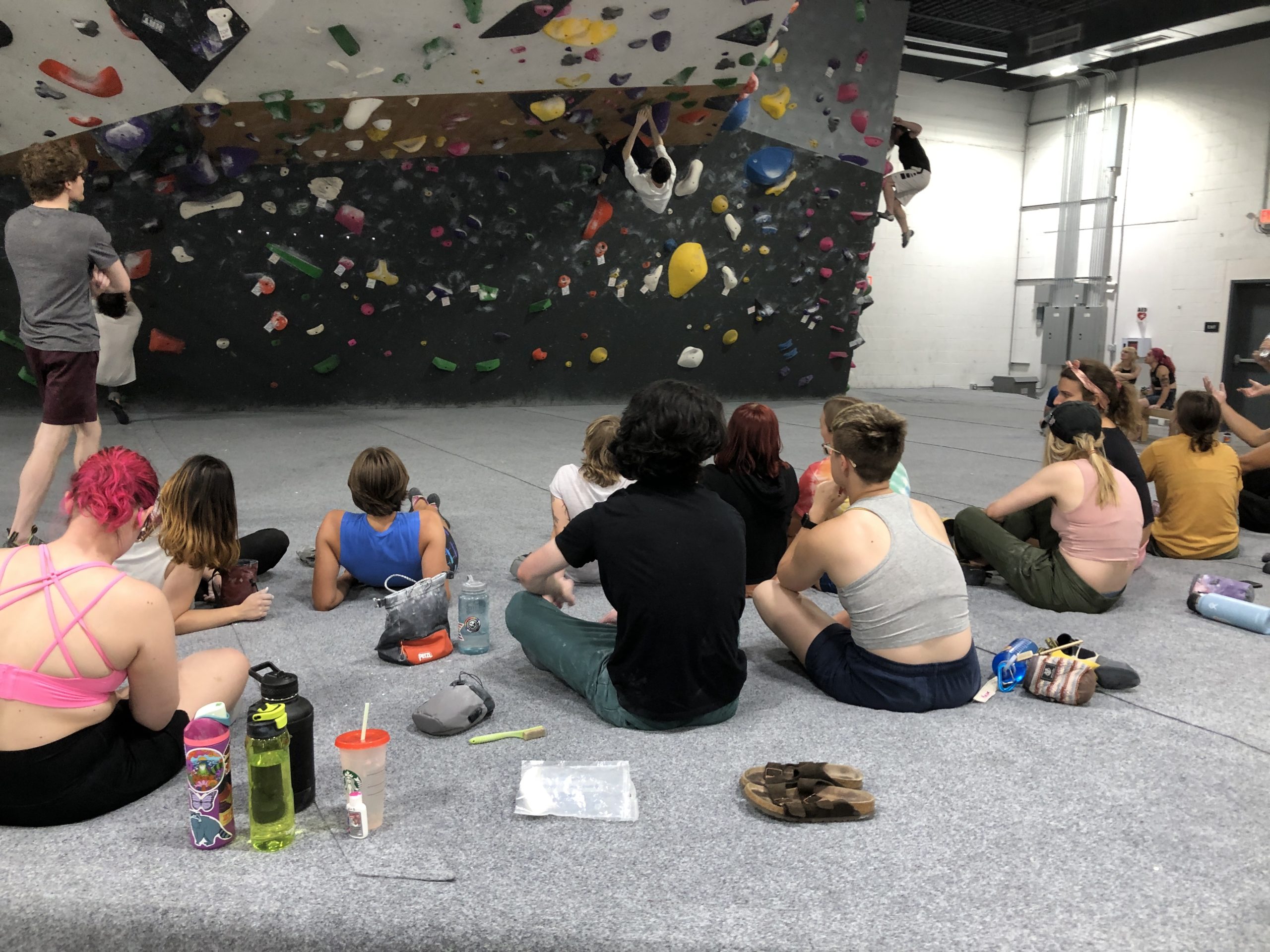 A group of climbers sitting, talking and watching others climb.