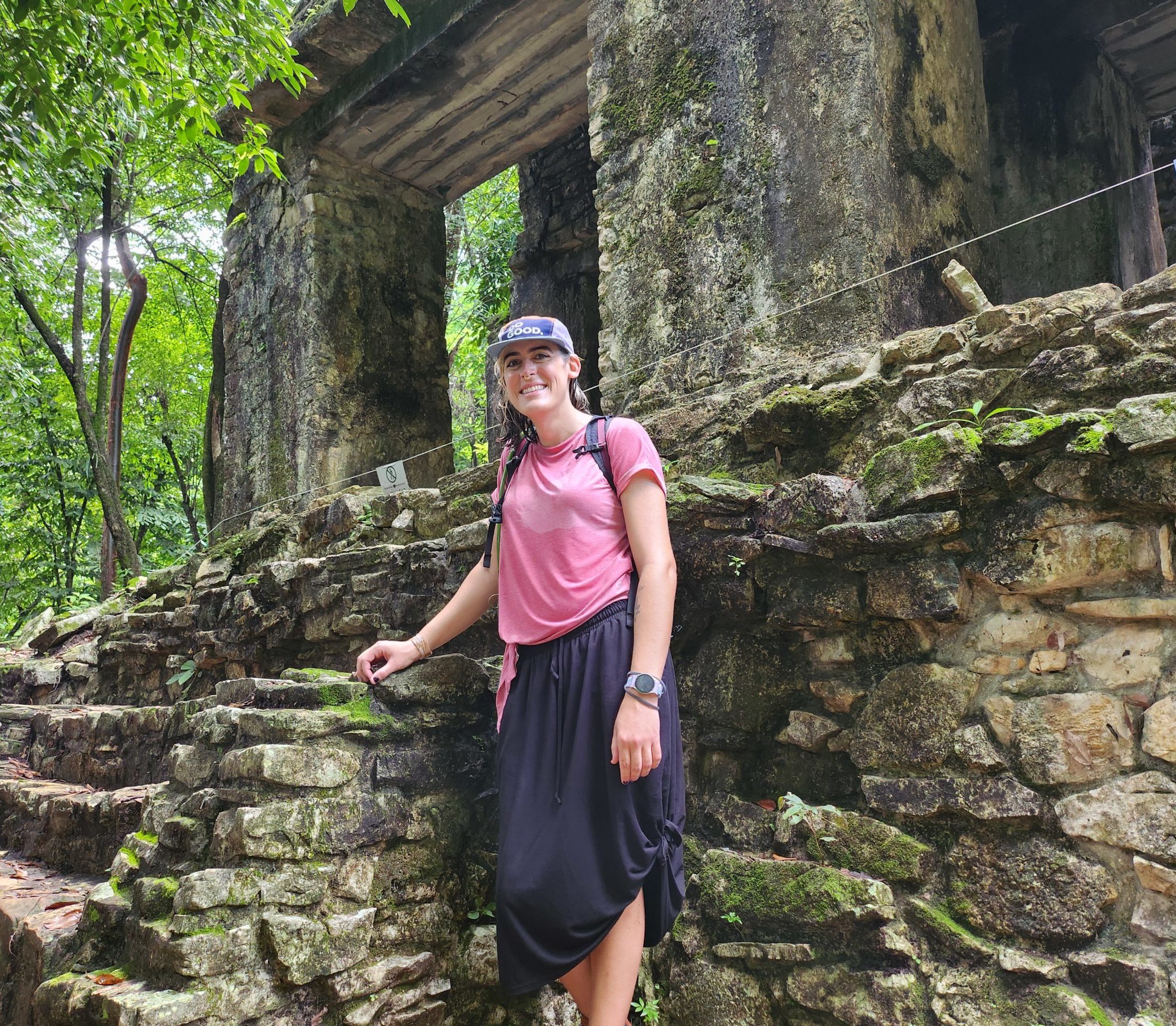 Ada standing in front of the ruins of a Maya temple surrounded by jungle.