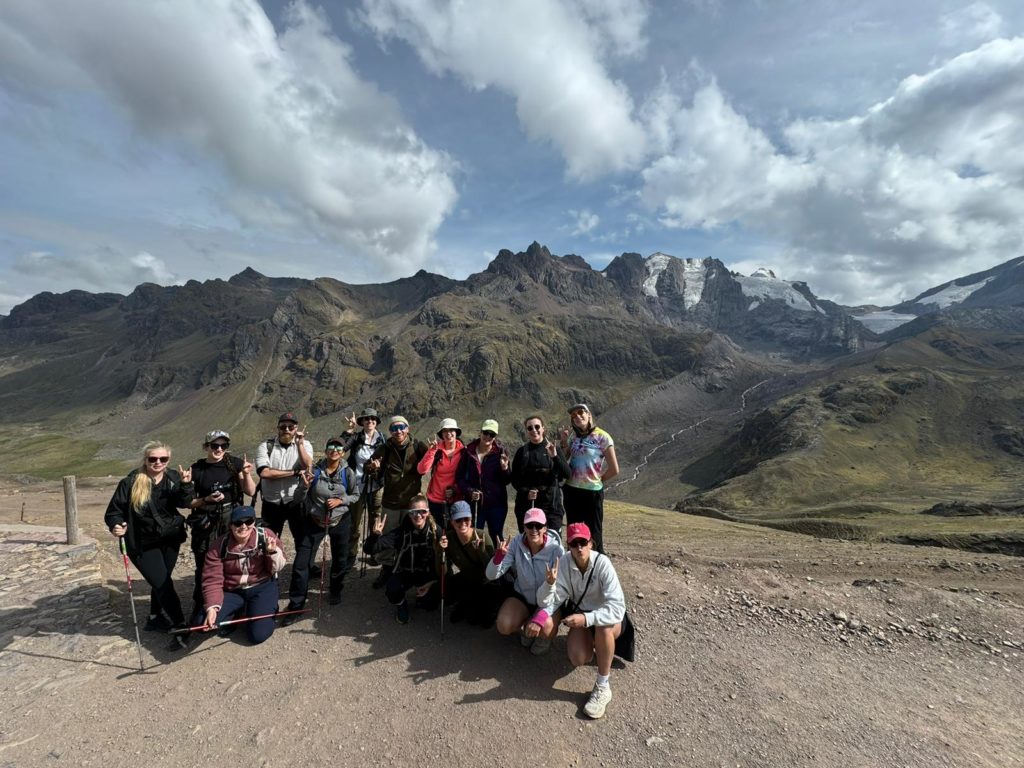 Photo of Ada's Peru travel group in front of glaciers and mountains, along the hike to Rainbow Mountain.