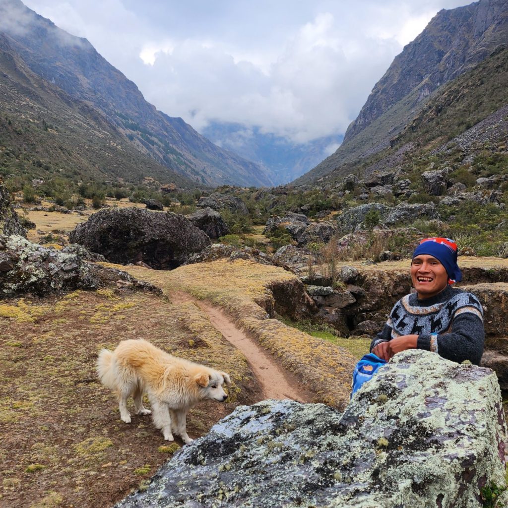 Photo of Johnny feeding a yellow sheepdog on the Lares Trek