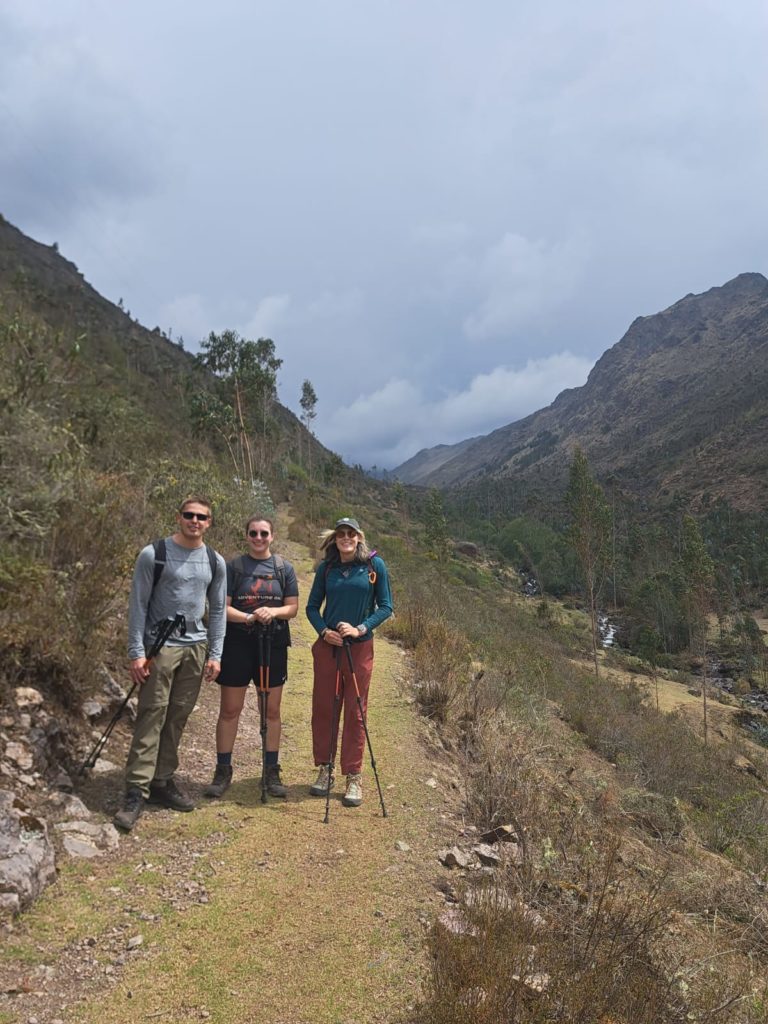 Photo of Ada and their hiking companions on the Lares Trek, standing on the edge of a valley.