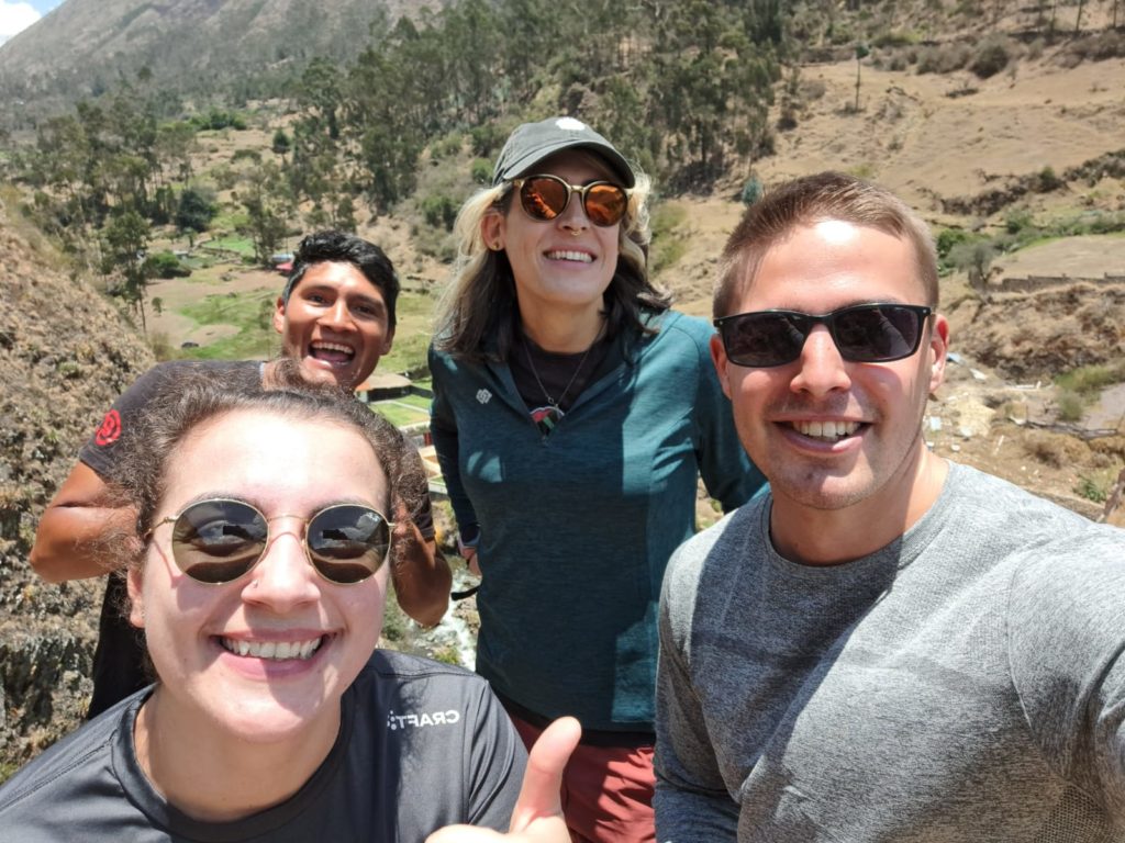 Selfie of Ada and their hiking companions on the Lares Trek, standing beside the hot springs in Lares Town, where they began the Trek.