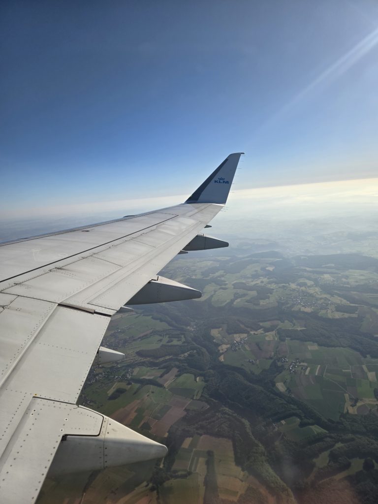 Photo from a plane window of the wing and Luxembourg city below.