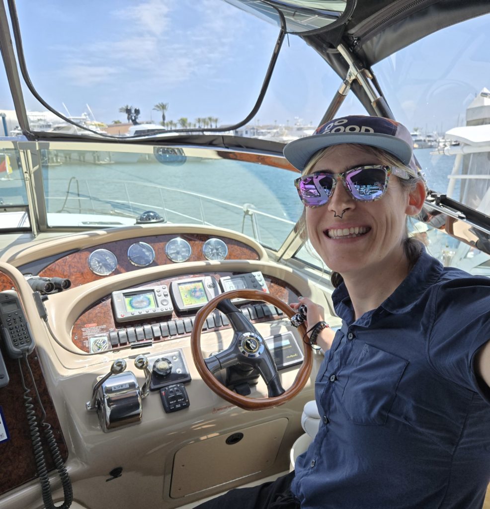 Photo of Ada at the helm of a small yacht